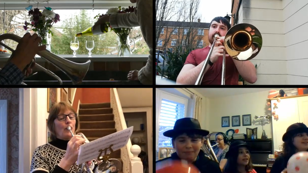 A grid of four video call screenshots showing brass band musicians playing instruments from their homes, including trombones and a flute, during a remote recording session.